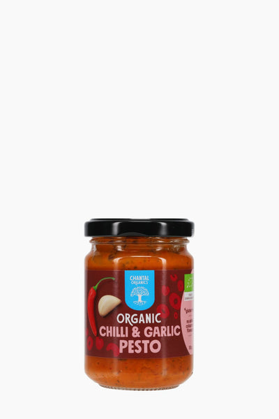 Jar of organic chili and garlic pesto on a white background