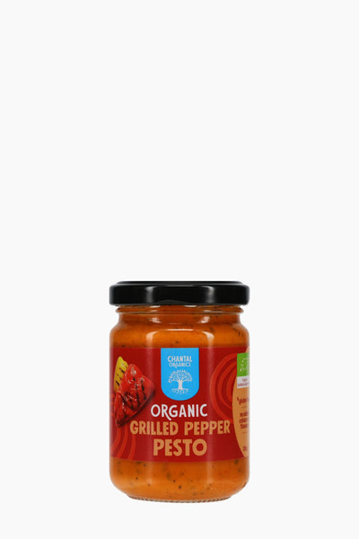 Jar of organic grilled pepper pesto on a white background
