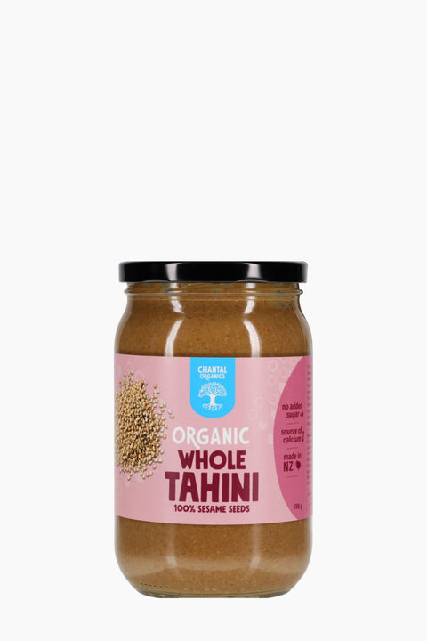 Jar of organic whole tahini with a pink label on a white background