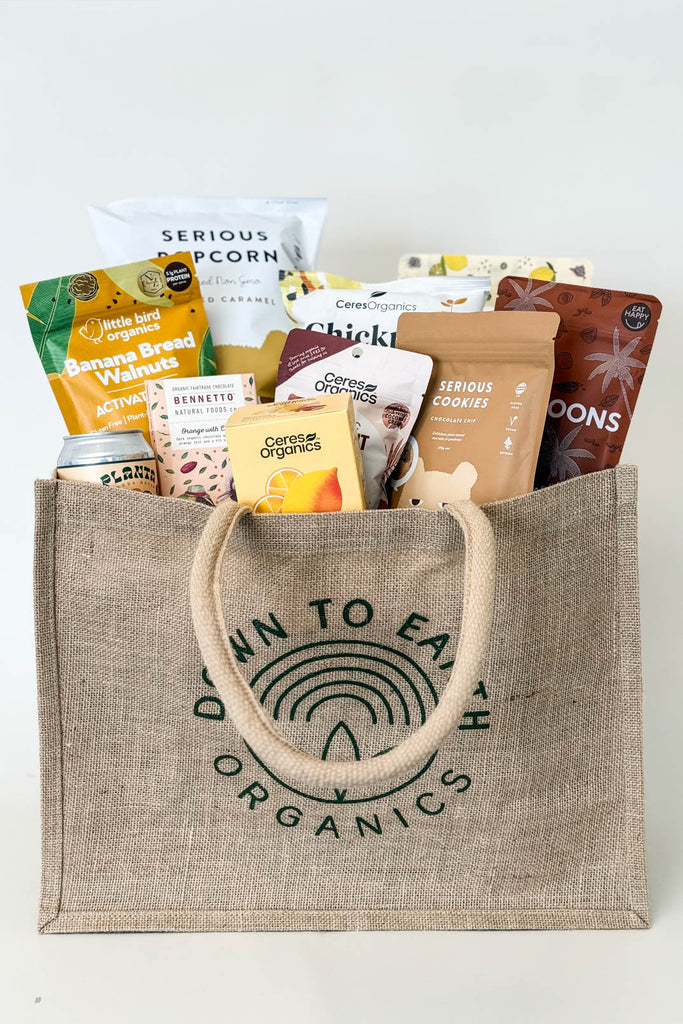 Jute bag filled with organic snacks and products on a white background