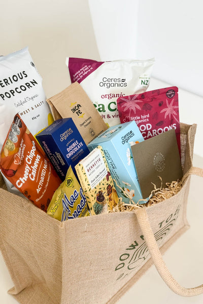 Gift Hamper ideas for birthdays, christmas, work - Assorted snacks and treats in a brown tote bag on a white background