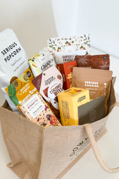 Gluten-Free Gift Hamper ideas for birthdays, christmas, work - Basket filled with various organic snacks on a white background