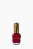 Red nail polish bottle with wooden cap on a white background