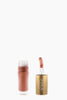 INIKA lip product with open cap on a beige background