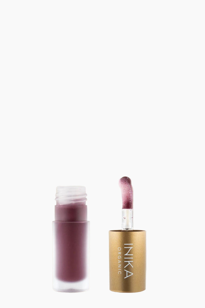 Inika lip product with open case on beige background
