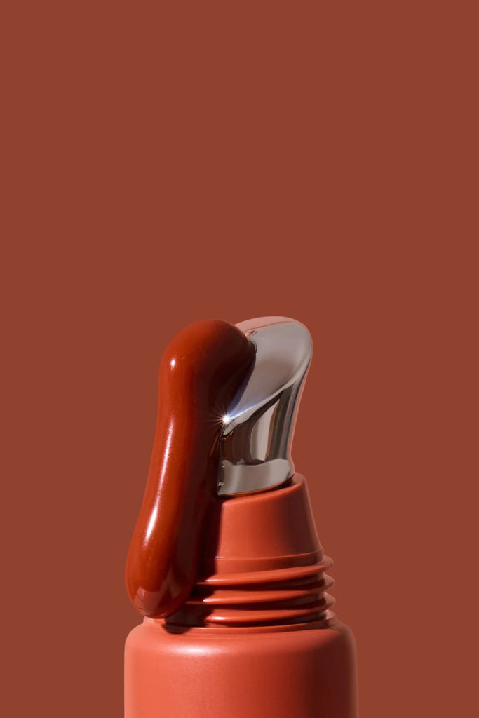 Close-up of a red lipstick with a brown background