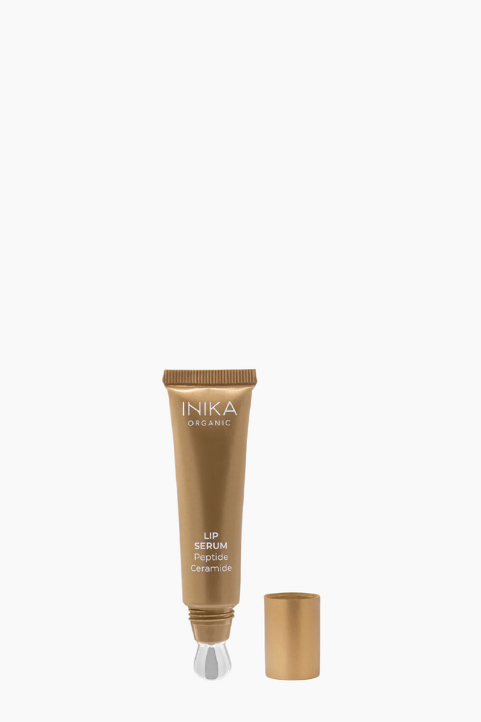 INIKA lip serum bottle on a beige background