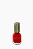Red nail polish bottle with wooden cap on a white background