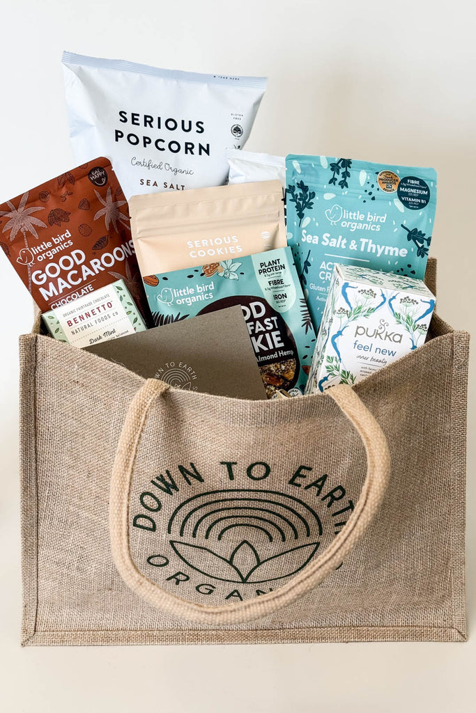 Plant-Based Gift Hamper ideas for birthdays, christmas, work - Jute bag with various organic snack packages on a white background