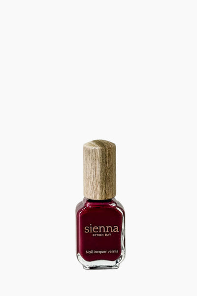 Nail polish bottle with wooden cap on a white background