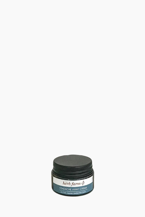 A jar of 'The Herb Farm Headache Away Cream' with a label that includes the product name and the scent marked as peppermint.