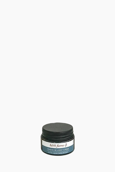 A jar of 'The Herb Farm Headache Away Cream' with a label that includes the product name and the scent marked as peppermint.